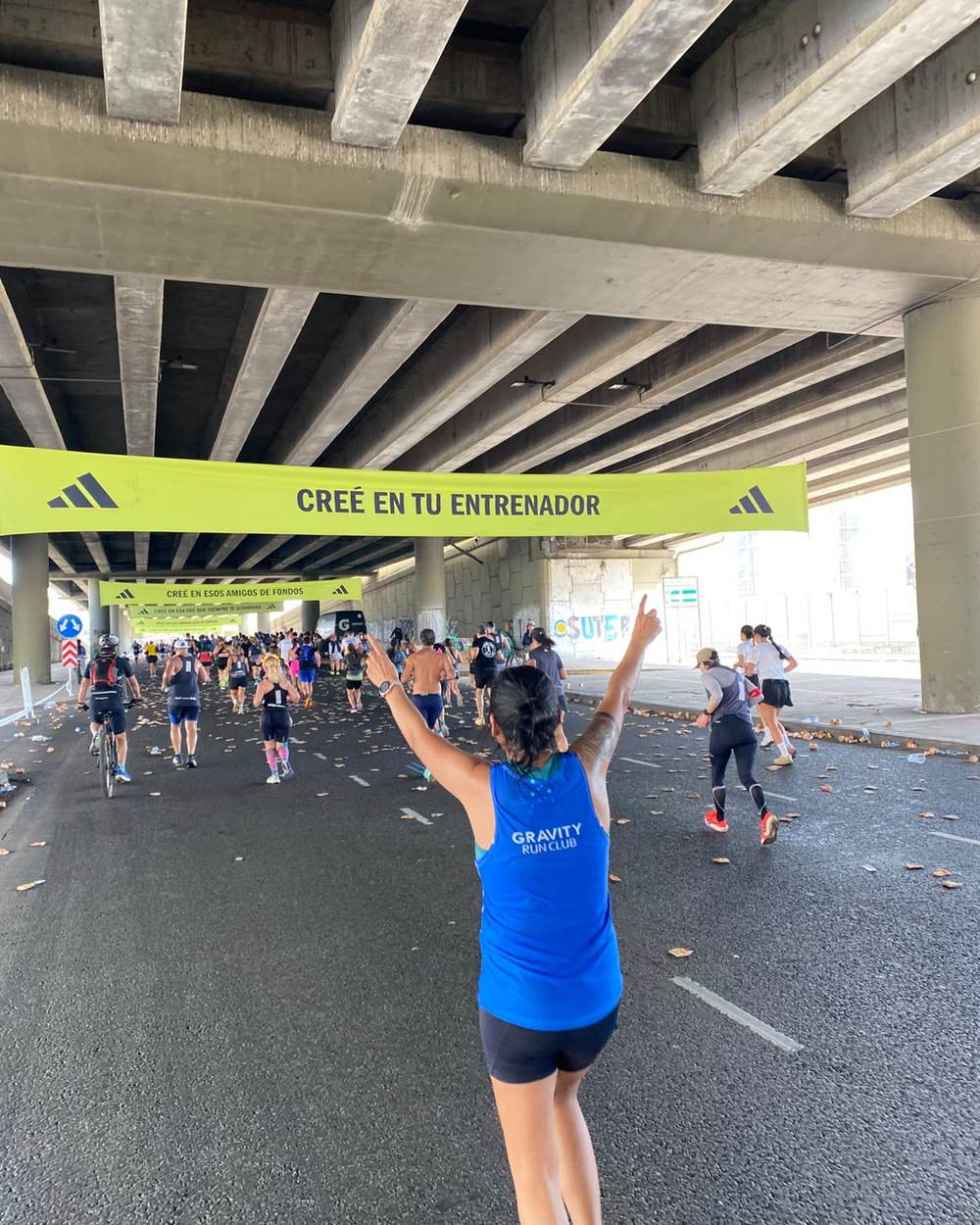 Griselda festejando bajo el banner Creé en tu entrenador en el Maratón de Buenos Aires